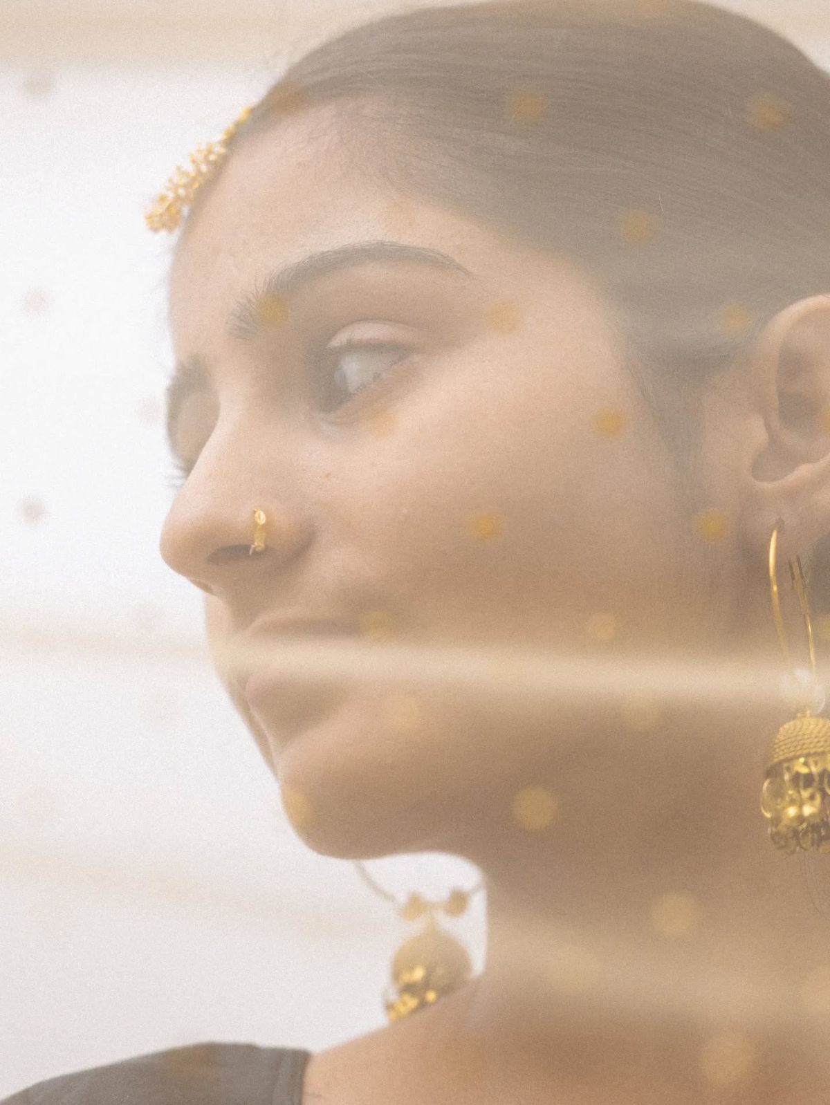 Woman wearing gold jhumka earrings by Damekii